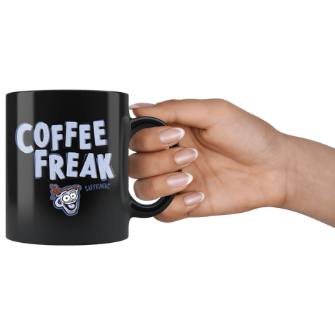Image of a woman's hand holding the handle of a black ceramic coffee mug with the Caffeiniac design COFFEE FREAK in light blue letters