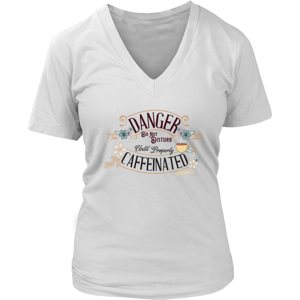 a women's white v neck t-shirt featuring the Caffeiniac design "Danger Do Not Disturb Until Properly Caffeinated".