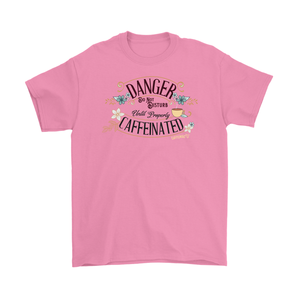 a men's pink t-shirt featuring the Caffeiniac design "Danger Do Not Disturb Until Properly Caffeinated".