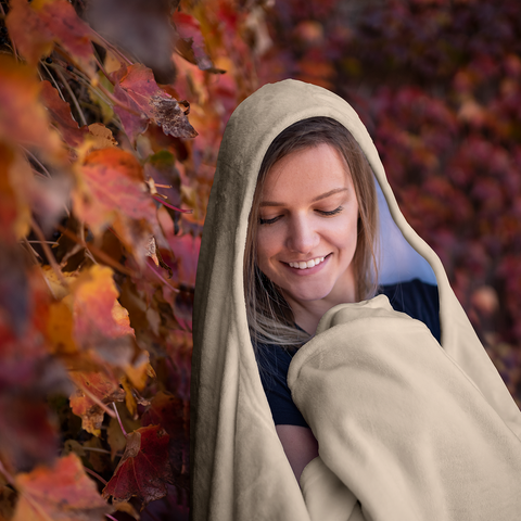 Image of smiling woman in a cozy soft hooded blanket