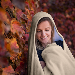 smiling woman in a cozy soft hooded blanket