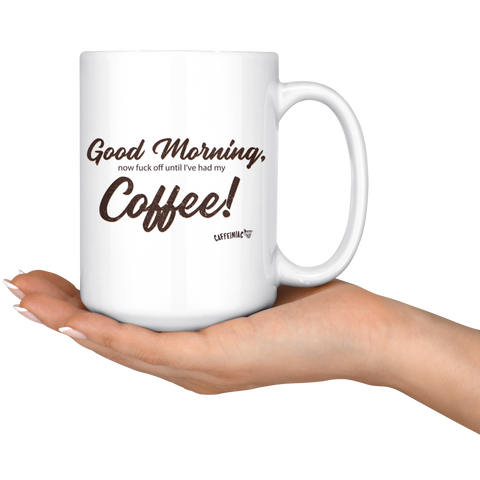 Image of a woman holding a 15oz white coffee mug with the original Caffeiniac design Good Morning, now fuck off until I've had my Coffee