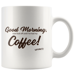 A white coffee mug with the original Caffeiniac design Good Morning, now fuck off until I've had my Coffee