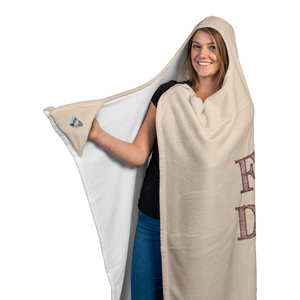 smiling woman wearing a soft hooded blanket showing the Caffeiinac Dude logo on the glove section