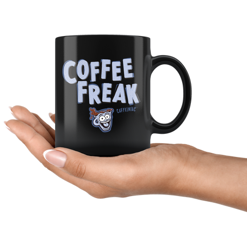 Image of a woman's hand holding a black ceramic coffee mug with the Caffeiniac design COFFEE FREAK in light blue letters