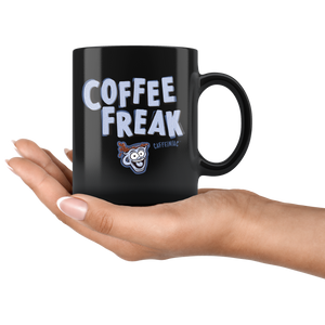 a woman's hand holding a black ceramic coffee mug with the Caffeiniac design COFFEE FREAK in light blue letters