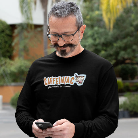 Image of man looking at his phone wearing a black long sleeve tshirt with Caffeiniac aficionado extreme design on the front