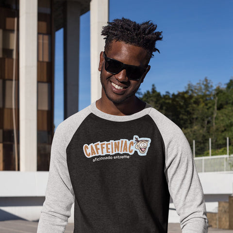 Image of smiling young man wearing a black raglan shirt with light grey sleeves featuring the Caffeiniac aficionado extreme logo on the front
