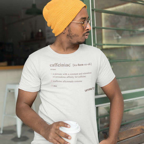 Image of man at a coffee shop holding a coffee wearing the original Caffeiniac defined design