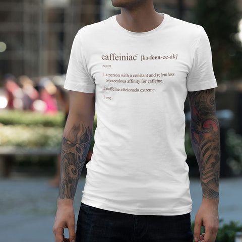 Image of tattooed man standing in a park wearing a white t-shirt featuring the Caffeiniac design "Caffeiniac defined"