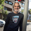 smiling man leaning against a pole wearing a Next Level Mens Long Sleeve T-Shirt featuring the original Caffeiniac Dude cup design on the front