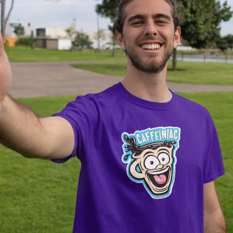 Image of Man taking selfie standing in park wearing a purple t-shirt featuring the original Caffeiniac dude cup design