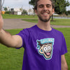 Man taking selfie standing in park wearing a purple t-shirt featuring the original Caffeiniac dude cup design