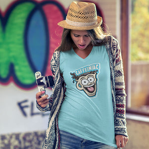 Woman standing wearing a v-neck light blue shirt featuring the original Caffeiniac Dude cup design on the front