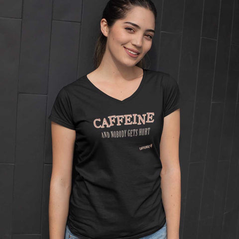 Image of woman standing near a wall wearing a blue v-neck Caffeiniac shirt with the design CAFFEINE and nobody gets hurt