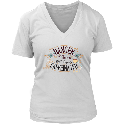 Image of a women's white v neck t-shirt featuring the Caffeiniac design "Danger Do Not Disturb Until Properly Caffeinated".