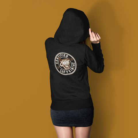Image of a woman standing near a well wearing a black hoodie with the Certified Caffeiniac design full size on the back