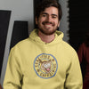smiling man wearing a yellow unisex hoodie with the Certified Caffeiniac design on the front