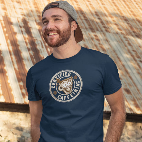 Image of smiling bearded man wearing a navy blue Canvas Mens T-Shirt featuring the original Certified Caffeiniac design on the front. 