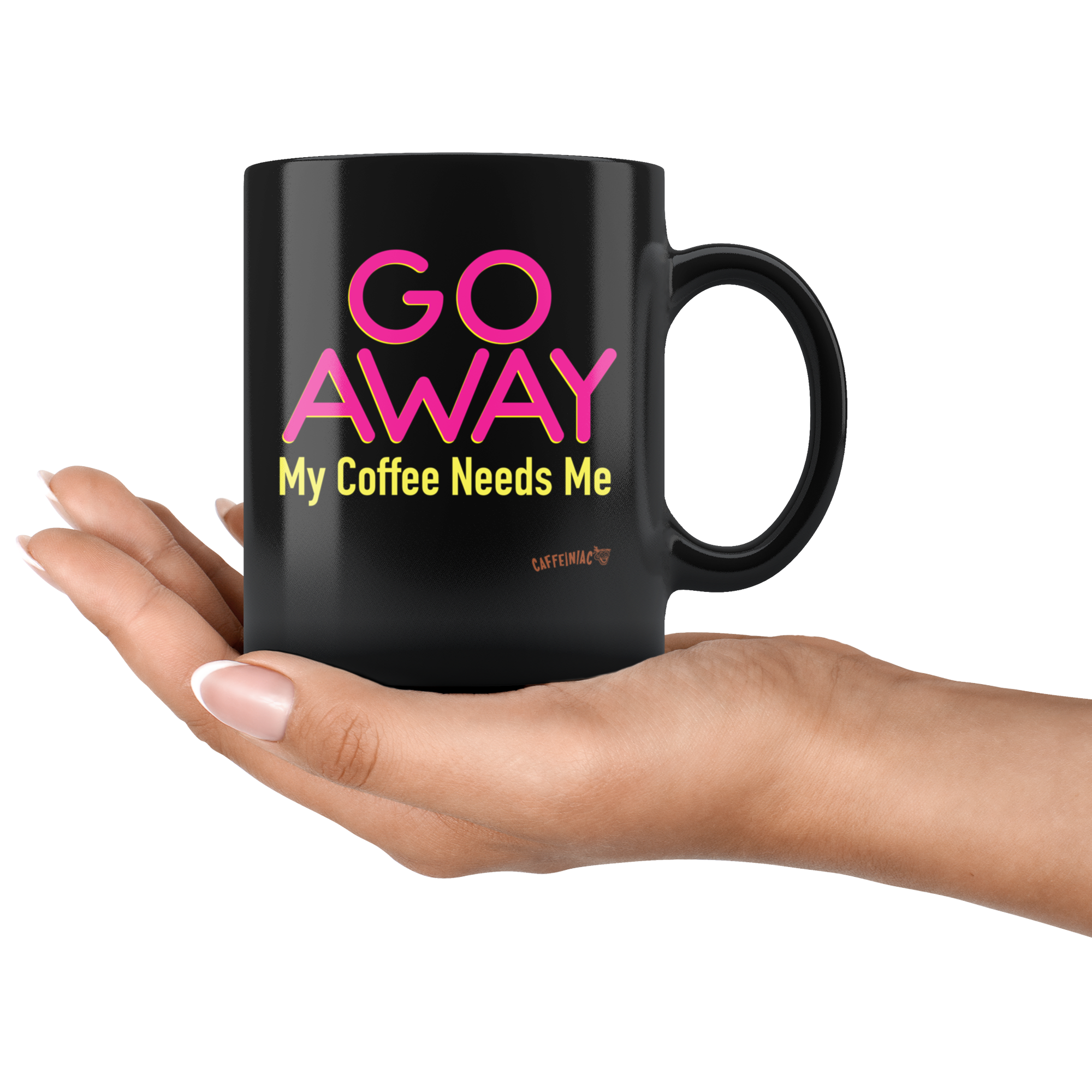 a black coffee mug featuring the Caffeiniac design "GO AWAY My Coffee Needs Me" in vibrant color on front and back in the palm of a woman's hand