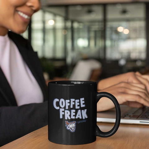 Image of black Caffeiniac coffee mug near a woman on a laptop