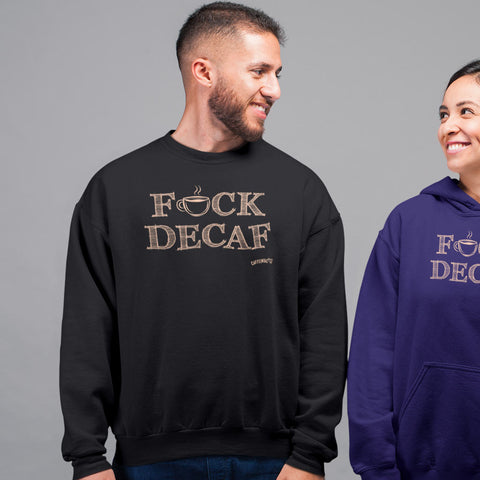Image of smiling man standing wearing a black crewneck sweatshirt with the original Caffeiniac design F_CK DECAF on the front in tan ink