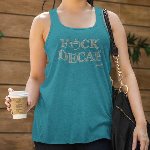 Image of woman at a coffee shop holding a cup of coffee wearing a teal tank top with the original Caffeiniac design F_CK DECAF on the front in tan ink