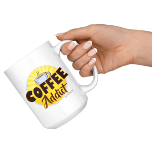 a hand holding  a white ceramic coffee mug with a vibrant Caffeiniac design " Coffee Addict" 
