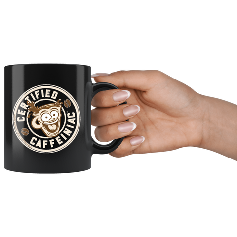 Image of a hand holding a  black coffee mug featuring the Certified Caffeiniac design in tan and brown printed on the front and back