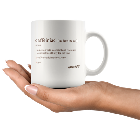 Image of a woman holding a white 11oz coffee mug with the original Caffeiniac defined design in brown ink