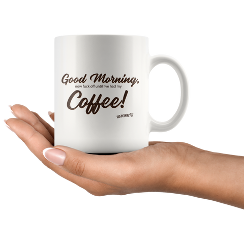 Image of a woman holding a white coffee mug with the original Caffeiniac design Good Morning, now fuck off until I've had my Coffee