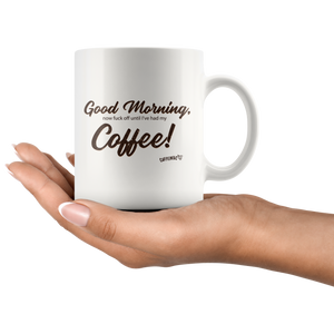 a woman holding a white coffee mug with the original Caffeiniac design Good Morning, now fuck off until I've had my Coffee
