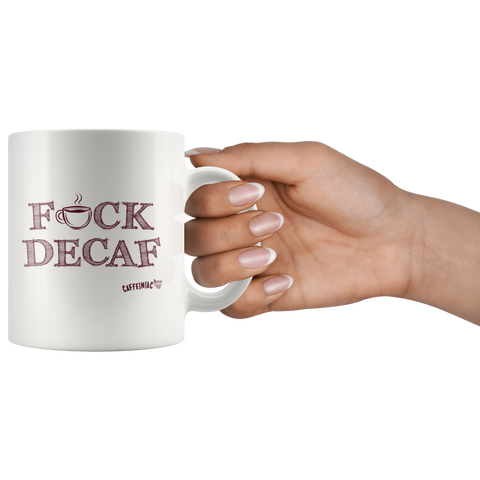 Image of a woman's hand holding the handle of a white 11oz coffee mug featuring the Caffeiniac F_CK DECAF design on front and back.