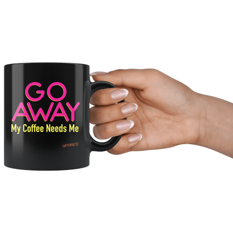 Image of a woman's hand holding a black coffee mug featuring the Caffeiniac design "GO AWAY My Coffee Needs Me" in vibrant color on front and back.