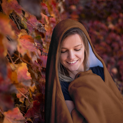 Image of woman wrapped in a cozy soft hooded blanket